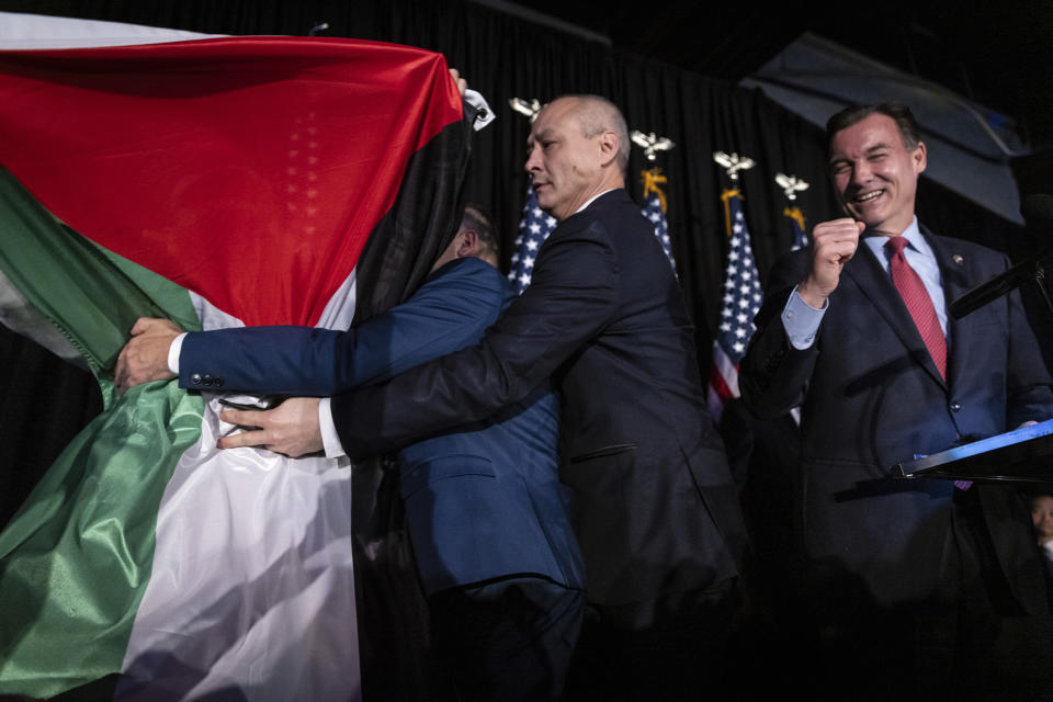 A protestor holding a Palestinian flag rushes the stage as former U.S. Rep. Tom Suozzi, Democratic candidate for New York's 3rd congressional district, speaks at his election night party Tuesday, Feb. 13, 2024, in Woodbury, N.Y. Suozzi won a special election for the House seat formerly held by George Santos. (AP Photo/Stefan Jeremiah)