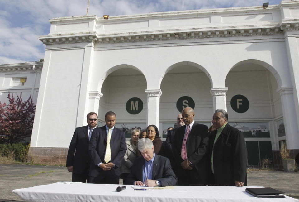 Michigan Gov. Rick Snyder signs legislation that returns fairgrounds to productive use during a bill signing ceremony at the Michigan State Fairgrounds in Detroit, Monday, April 9, 2012. The governor signed two bills aimed at setting the stage for possible redevelopment of the 162-acre site. (AP Photo/Carlos Osorio)