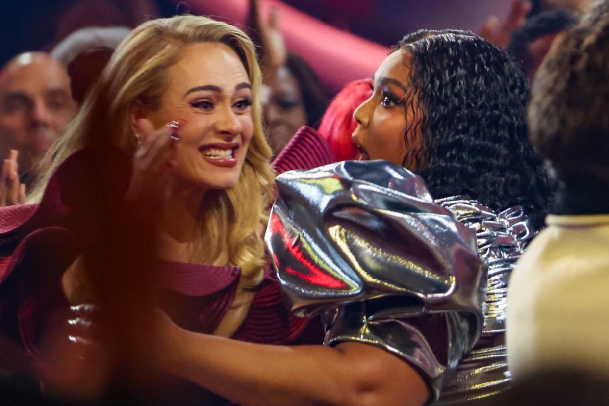 Lizzo embraces Adele as she gets up to accept the award for record of the year at the 65th Grammy Awards.