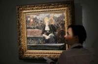 A Sotheby's employee poses with "Le bar aux Folies-Bergere" by Edouard Manet at Sotheby's in London, Britain June 19, 2015. REUTERS/Suzanne Plunkett
