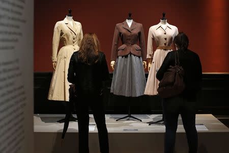 Visitors look at vintage dresses by designers Jacques Fath, Jacques Heim and Christian Dior presented in the exhibition "Les Annees 50, La mode en France" (The 50s. Fashion in France, 1947-1957) at the Palais Galliera fashion museum in Paris, July 10, 2014. REUTERS/Benoit Tessier