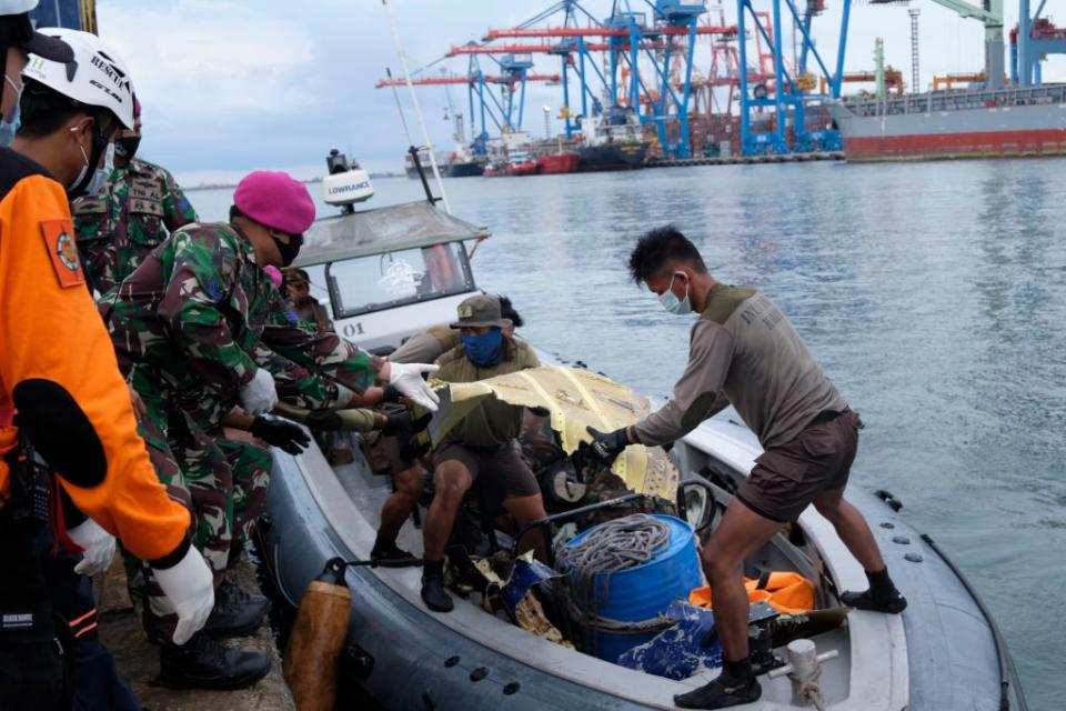 Indonesian Marines offload bits of debris from Sriwijaya Air flight SJ182 from their boat in Jakarta, Indonesia. 