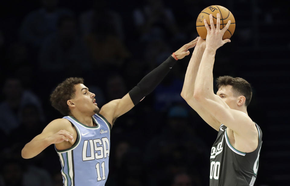 U.S. Team's Trae Young, of the Atlanta Hawks works against World Team's, Rodions Kurucs, of the Brooklyn Nets during the NBA All-Star Rising Stars basketball game, Friday, Feb. 15, 2019, in Charlotte, N.C. (AP Photo/Chuck Burton)