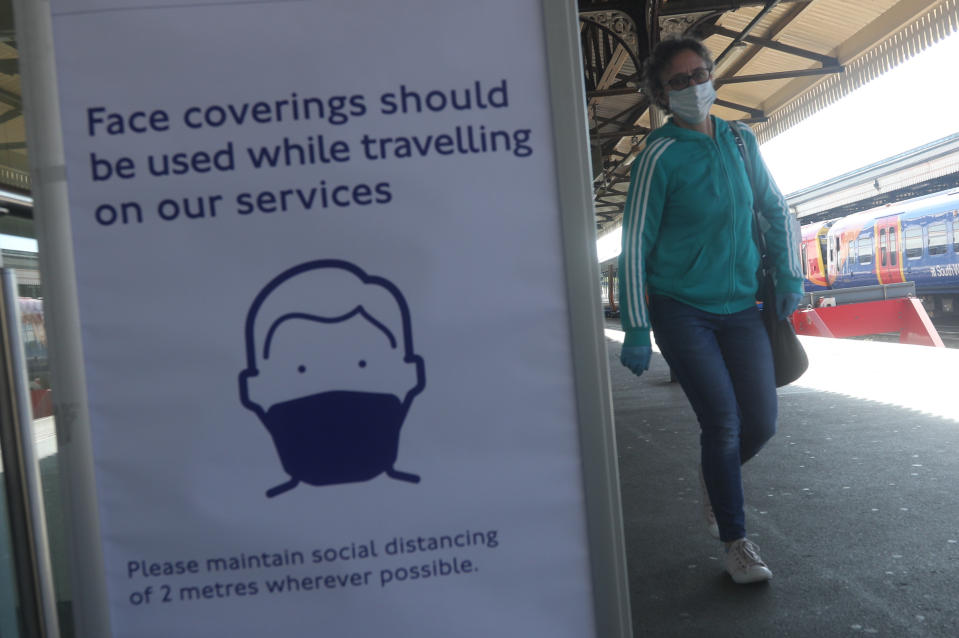 A sign advising passengers to wear a face mask at Clapham Junction station, London, as train services increase as part of the easing of coronavirus lockdown restrictions. (Photo by Yui Mok/PA Images via Getty Images)