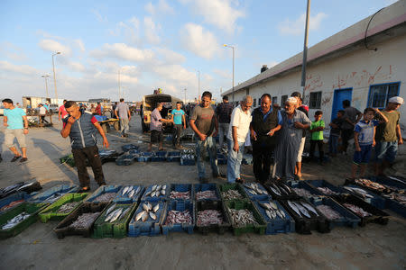 Palestinians look at fish displayed for sale in Gaza City August 15, 2018. REUTERS/Ibraheem Abu Mustafa