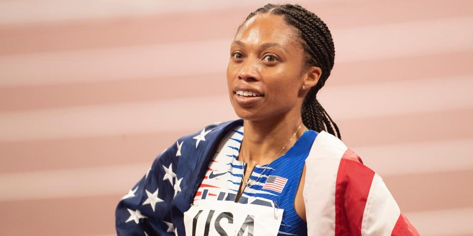 Allyson Felix wears the American flag around her shoulders at the Tokyo Olympics.