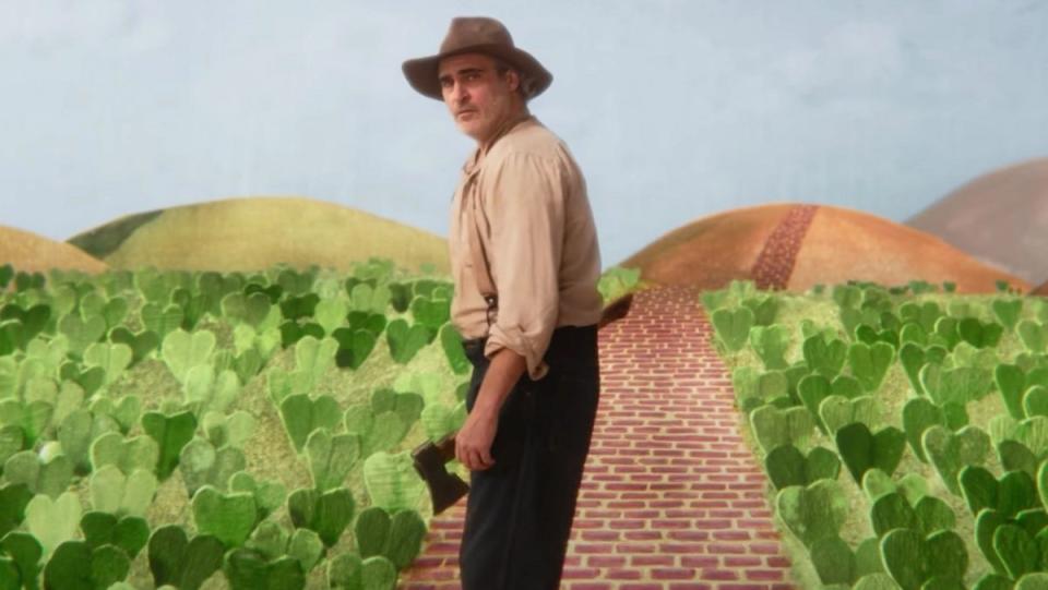 Joaquin Phoenix wears an old-timey farmer outfit and carries a hatchet in a surrealistic play in Beau Is Afraid.