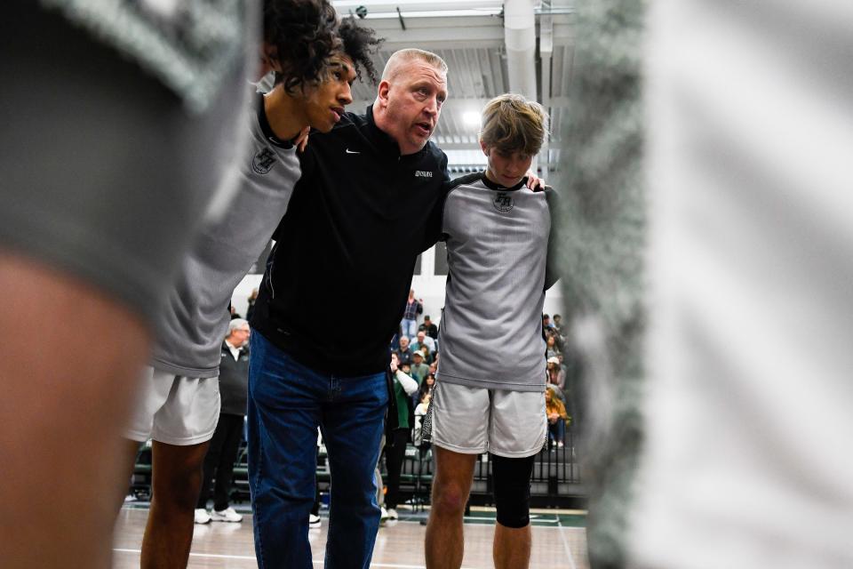 Fossil Ridge head coach Matt Johannsen speaks to the team in a huddle before a second-round high school basketball playoff game against Doherty at Fossil Ridge High School on Feb. 25 in Fort Collins. The SaberCats won 72-43.