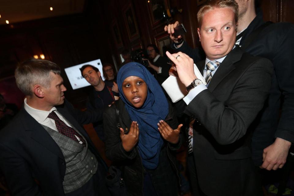 A woman among a small group of protesters being escorted out of a room at the Marriott County Hall hotel (PA)