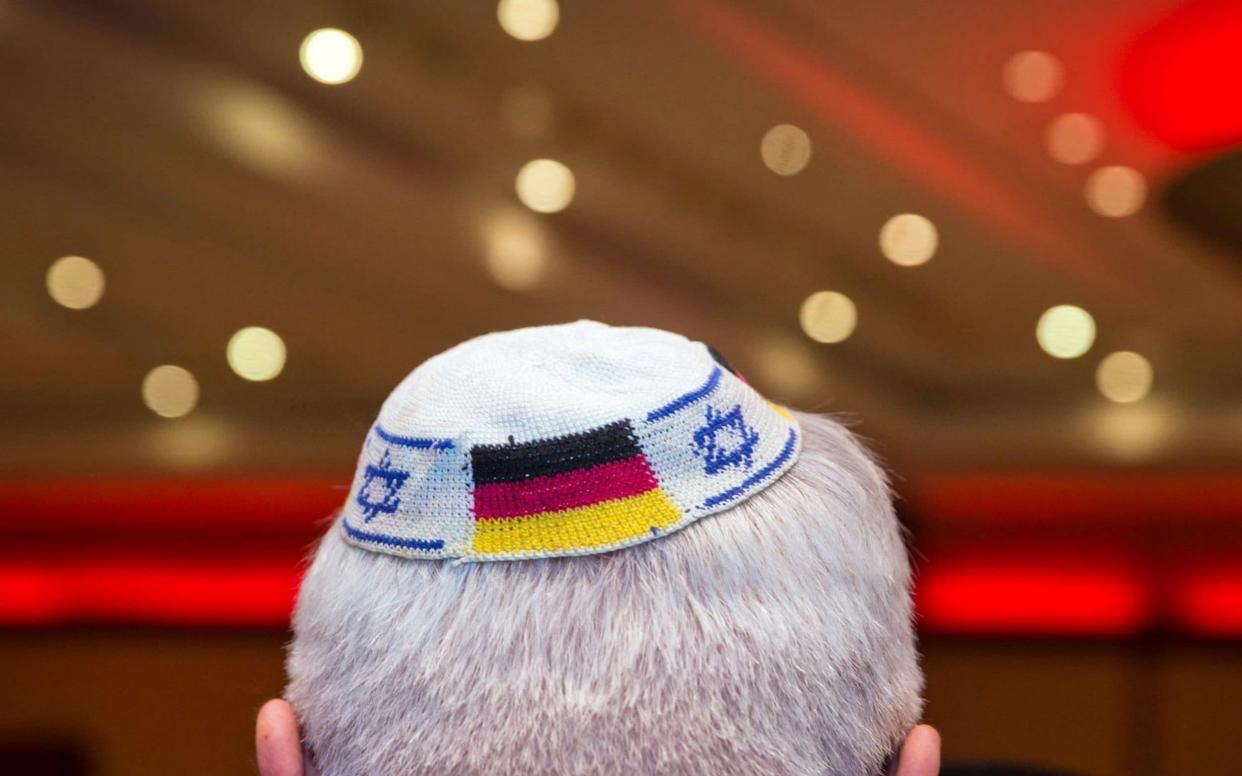 A man wearing a Jewish kippa skullcap with the flags of Germany and Israel - DPA