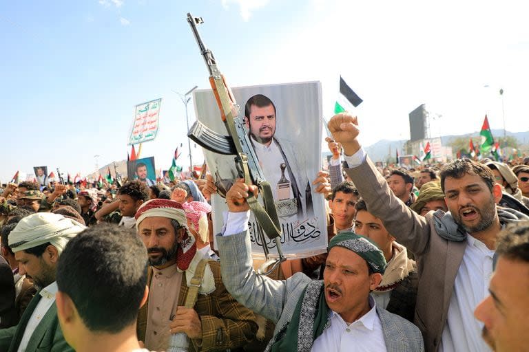 Los manifestantes, uno de ellos con un retrato del líder hutí Abdul Malik al-Houthi, gritan consignas durante una marcha en solidaridad con el pueblo de Gaza en Saná, la capital controlada por los hutíes, el 5 de enero de 2024, en medio de las batallas en curso entre Israel y Hamas. (MOHAMMED HUWAIS / AFP)