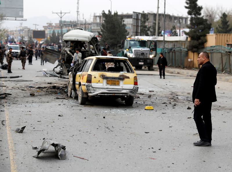 FILE PHOTO: Afghan officials inspect a damaged minibus after a blast in Kabul
