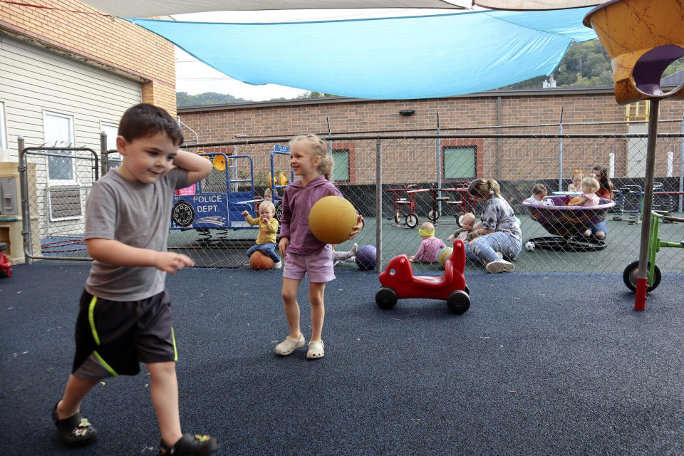 Children play on a rubber playground purchased in part with the support of pandemic-era stabilization aid at Living Water Child Care and Learning Center in Williamson, W.Va. on Monday, Sept. 25, 2023. (AP Photo/Leah Willingham)