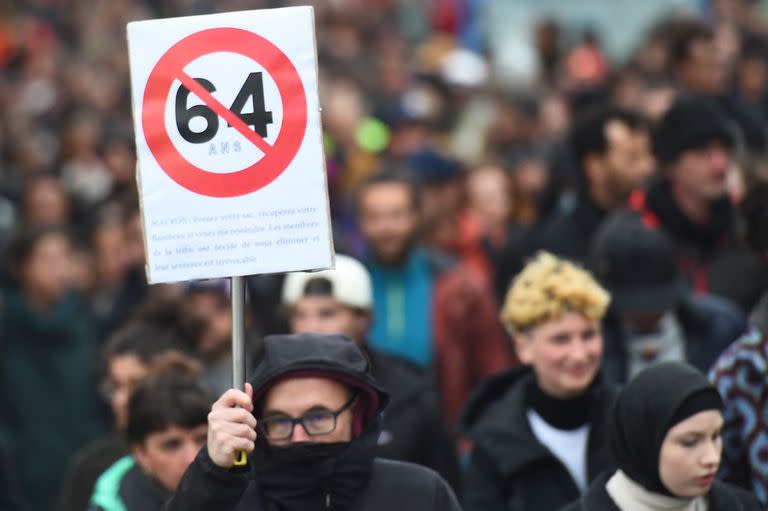 Un manifestante, sosteniendo una señal de carretera de dirección prohibida con una cruz de 64 años, participa en una manifestación después de que el Consejo Constitucional de Francia aprobara los elementos clave de la reforma de las pensiones del presidente francés, en Nantes, oeste de Francia, el 14 de abril de 2023.