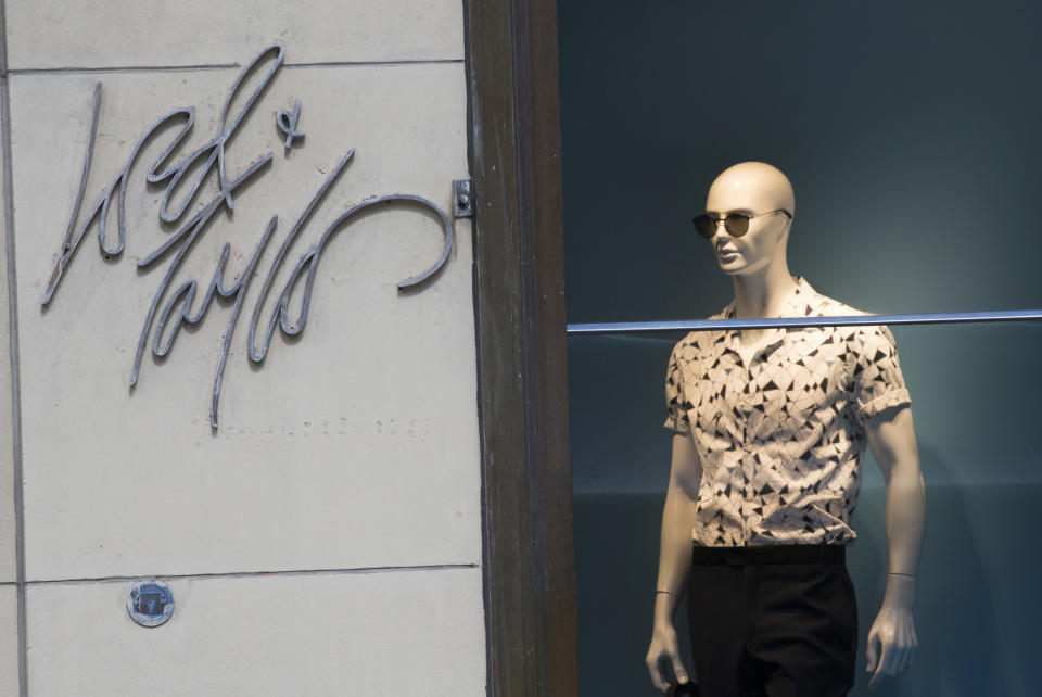 FILE - In this June 6, 2018, file photo the Lord & Taylor logo is seen next to a mannequin in a window display at their flagship store on Fifth Avenue in New York. Lord & Taylor, one of the nation’s oldest department stores, is being sold for $100 million. The retailer’s owner, Hudson's Bay Co., says it reached a deal with online rental clothing company Le Tote Inc. (AP Photo/Mary Altaffer, File)
