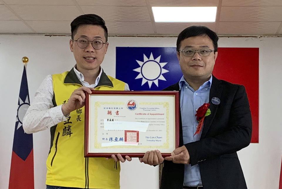 In this photo taken June 20, 2019, and released by Pingtung County Fangliao Township Office, Lee Meng-chu, right, accepted a certificate for his adviser role from Archer Chen, Chief of Fangliao Township, during a ceremony in Pingtung County, southern Taiwan. Taiwan is seeking information from China about Lee who has gone missing since last week and who had reportedly distributed photos of Chinese troops just outside protest-racked Hong Kong. (Pingtung County Fangliao Township Office via AP)