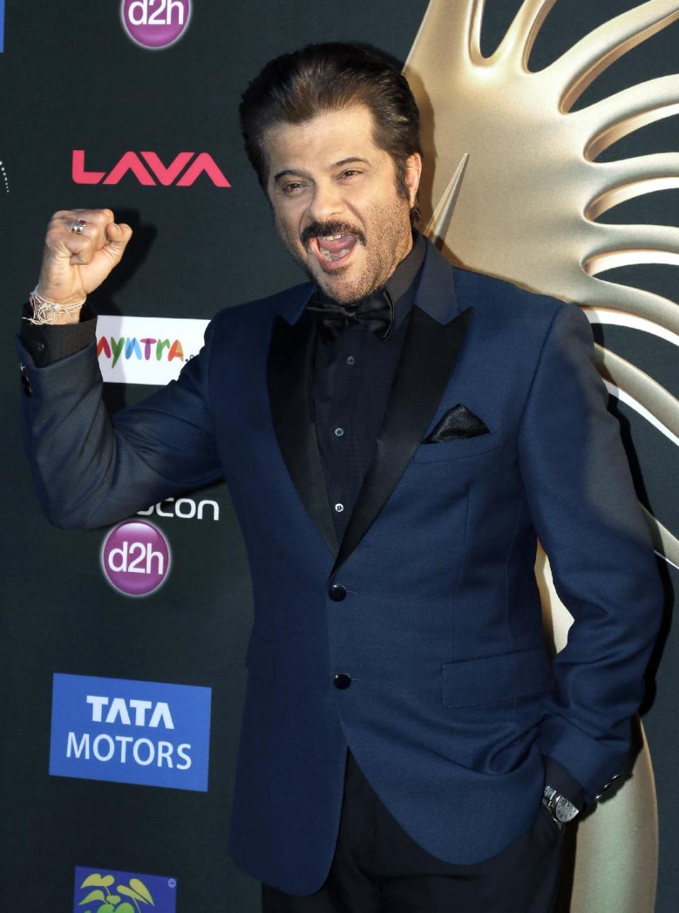 Indian film star Anil Kapoor gestures as he poses for photographers along the green carpet as he arrives for 15th annual International Indian Film Awards Saturday, April 26, 2014, in Tampa, Fla. (AP Photo/Chris O'Meara)