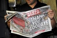 Printer James Bradley looks at a copy of the final edition of the News of the World as the presses print the newspaper at the News International print works in Waltham Cross, southern England July 9, 2011. REUTERS/Ian Nicholson/Pool