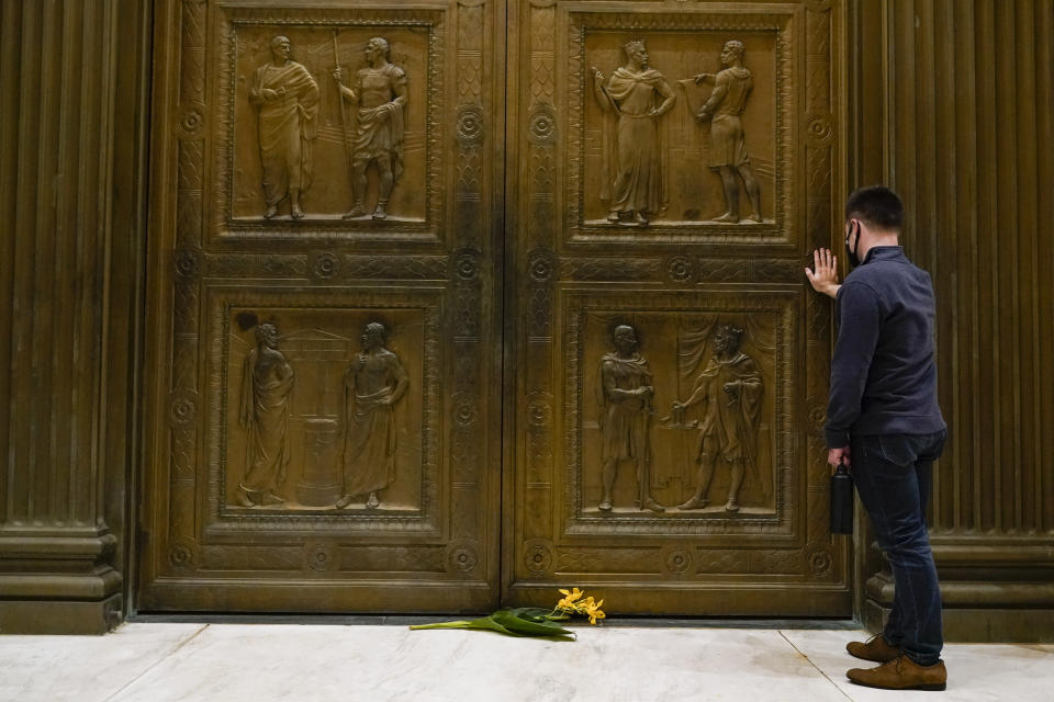 A man touches the door of the Supreme Court Friday, Sept. 18, 2020, in Washington, after the Supreme Court announced that Supreme Court Justice Ruth Bader Ginsburg has died of metastatic pancreatic cancer at age 87. (AP Photo/Alex Brandon)