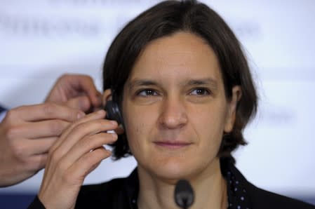 French economist Esther Duflo gets fitted with an earphone before a news conference in Oviedo,