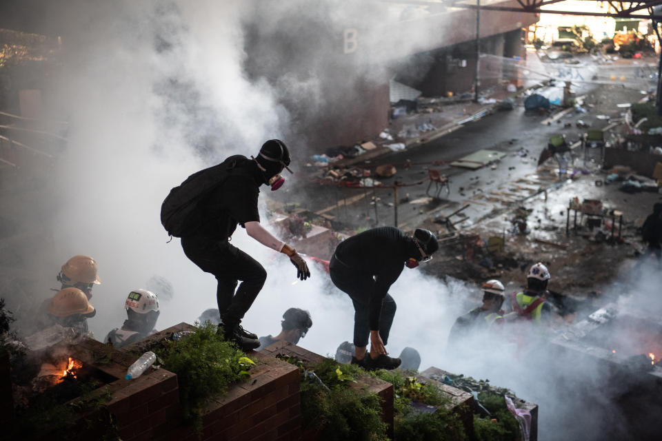 Anti-government protesters walk past a fire during clashes with police at Hong Kong Polytechnic University on Nov. 18, 2019 in Hong Kong, China. (Photo: Laurel Chor/Getty Images)