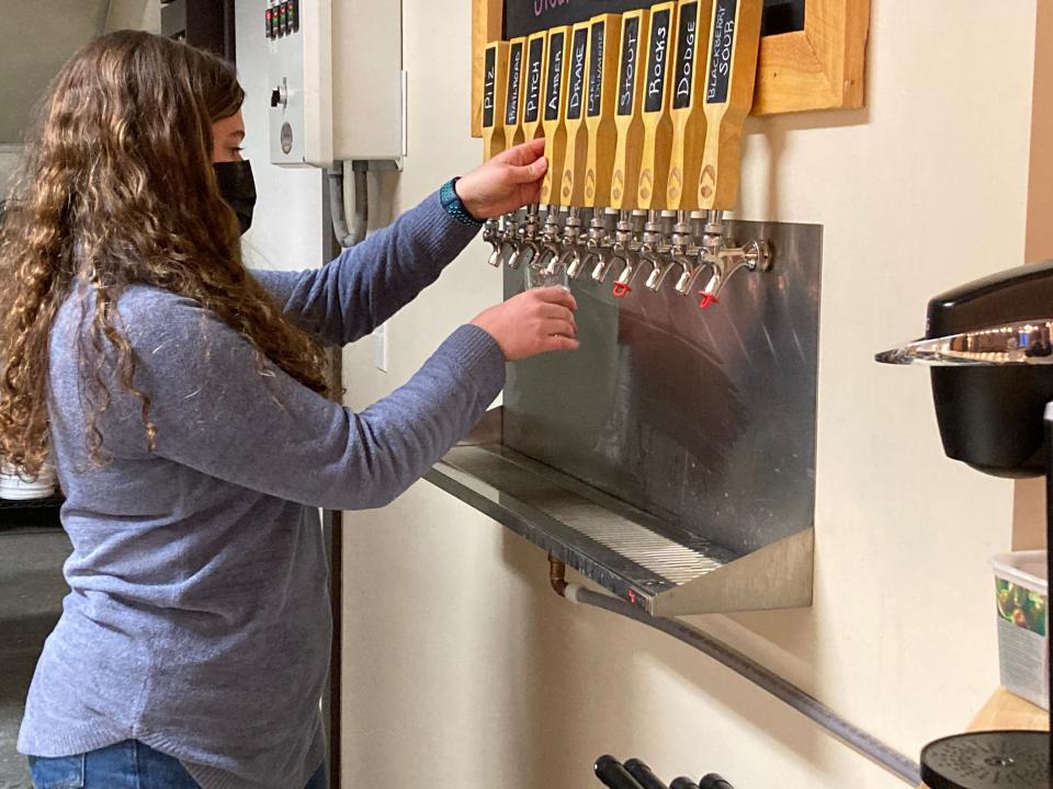 Celia Heath pours an amber ale Jan. 7, 2022 at Hogback Mountain Brewing in Bristol.