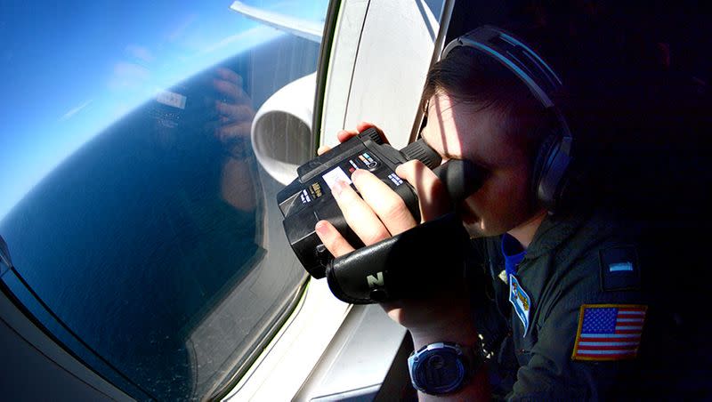 FILE PHOTO: A member of the US Navy, aboard the Boeing P-8A Poseidon plane, looks down as they fly over the South Atlantic Ocean during the search for the ARA San Juan submarine missing at sea