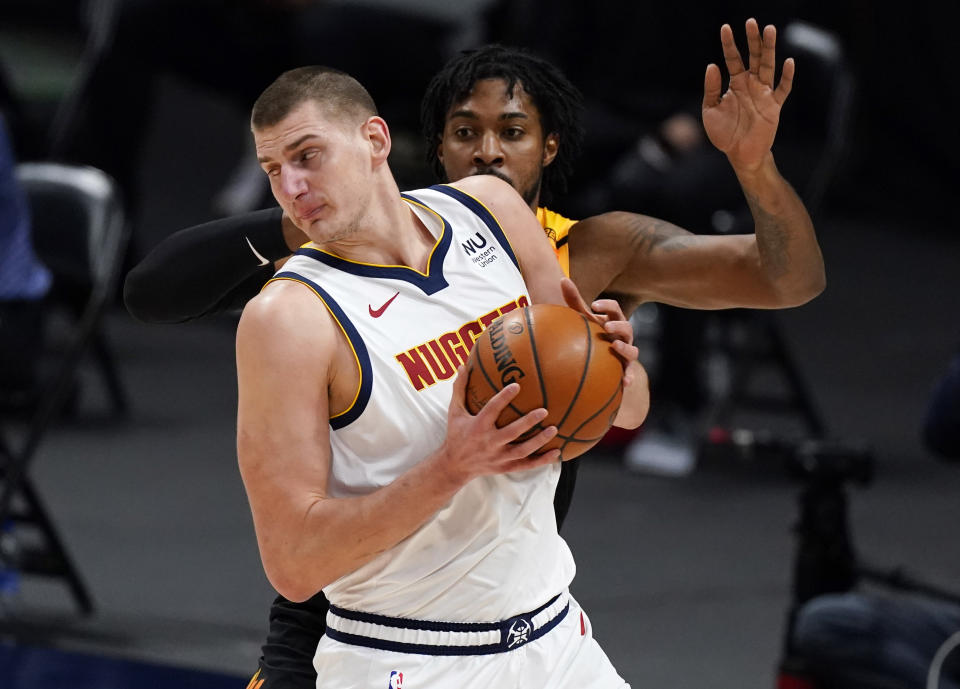 Denver Nuggets center Nikola Jokic, front, works the ball inside as Utah Jazz center Derrick Favors defends in the first half of an NBA basketball game Sunday, Jan. 31, 2021, in Denver. (AP Photo/David Zalubowski)