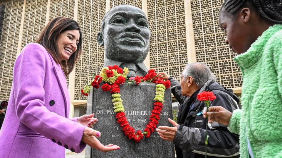 Fresno County Superintendent of Schools Dr. Michele Cantwell-Cophers, left, and Dr. Sudarshan Kapoor, center, help students place flowers on the MLK memorial bust during the annual Martin Luther King garlanding event at Fresno County Courthouse Park in Fresno on Friday, Jan. 13, 2023.The 39th annual events were kicked off with the garlanding ceremony at the MLK memorial bust to honor and remember slain civil rights leader Rev. Dr. Martin Luther King Jr. CRAIG KOHLRUSS/ckohlruss@fresnobee.com