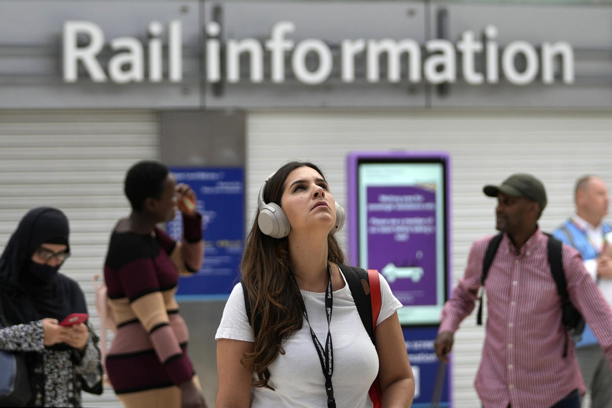A traveller looks at the train departure board at Waterloo Station as members of the Rail, Maritime and Transport union (RMT) began fresh nationwide strikes in a bitter dispute over pay, jobs and conditions in London, Thursday, Aug. 18, 2022.(AP Photo/Frank Augstein)