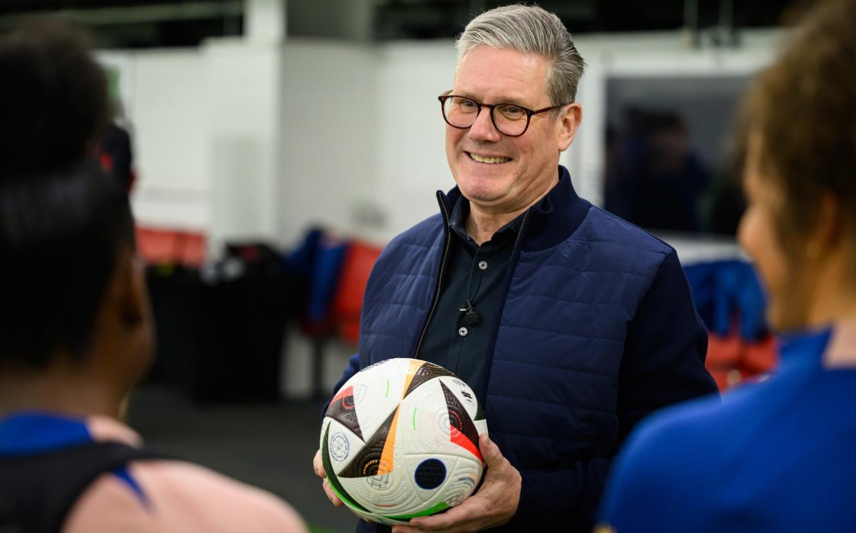 Sir Keir Starmer, the Labour leader, speaks with players from the women's U17 England football squad during a visit to St George's Park in Burton Upon Trent