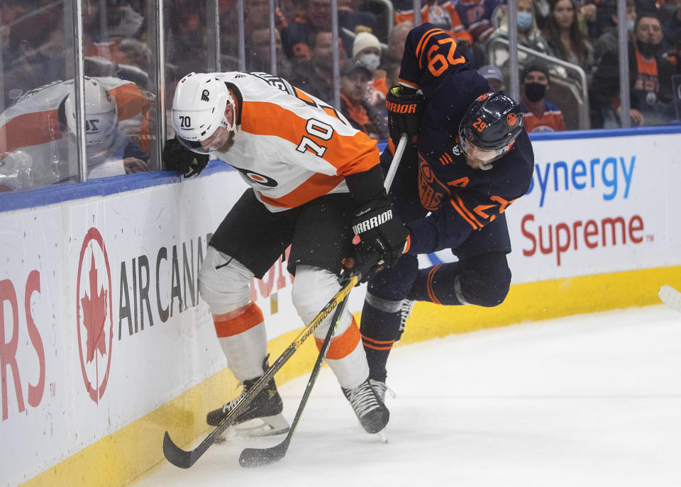 Philadelphia Flyers' Rasmus Ristolainen (70) and Edmonton Oilers' Leon Draisaitl (29) battle for the puck during the second period of an NHL hockey game, Wednesday, Oct. 27, 2021 in Edmonton, Alberta. (Jason Franson/The Canadian Press via AP)