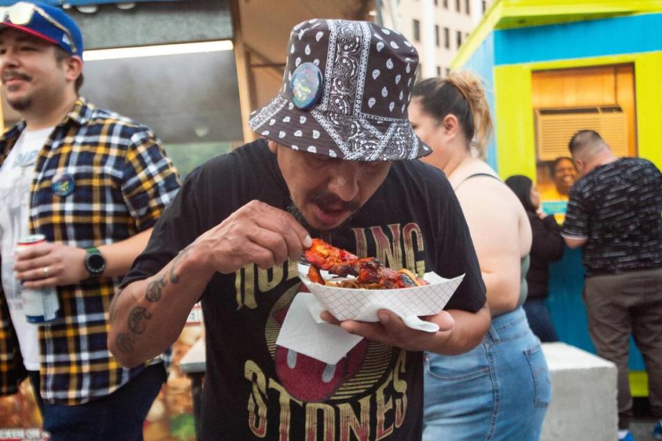 A Riverfest attendee eats chicken on a stick from Chan’s Concessions. The food vendor served various Asian meals and snacks.