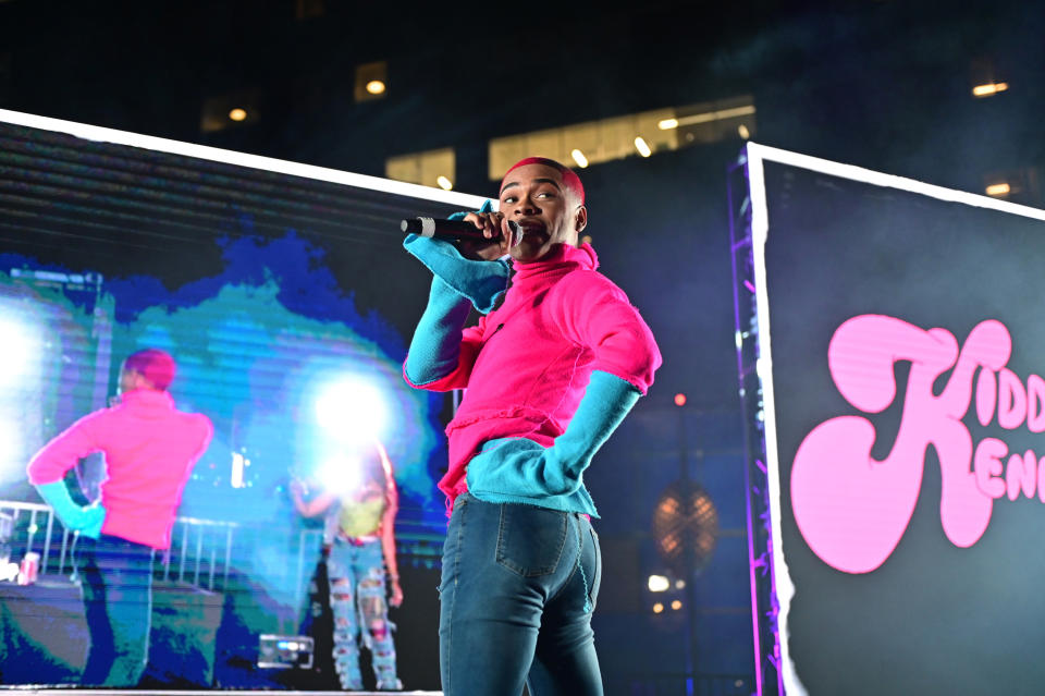 Kidd Kenn performing onstage with a microphone in hand