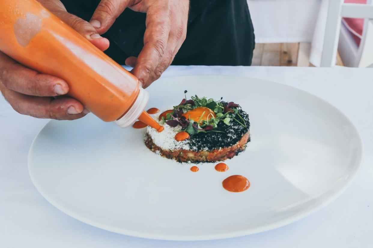 hands plating a gourmet meal