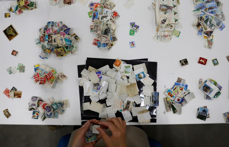 Buysell Technologies worker sorts out stamps in Funabashi