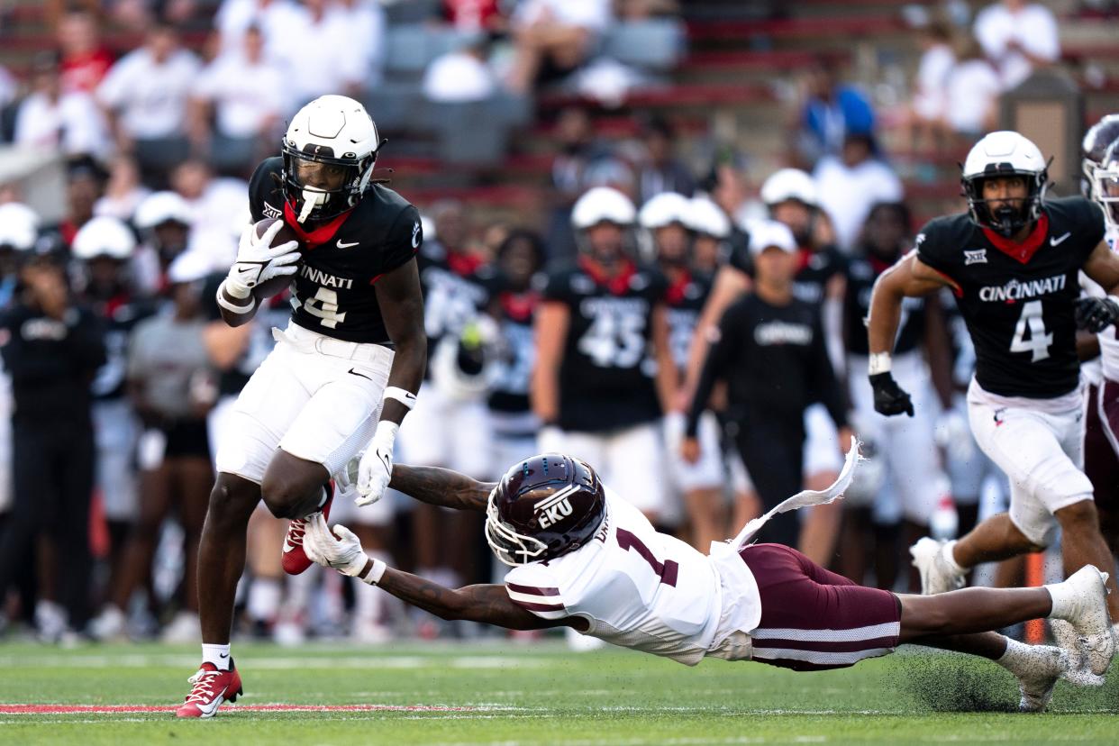 Cincinnati Bearcats wide receiver Barry Jackson Jr. (14) breaks a tackle attempt by Eastern Kentucky Colonels defensive back Tony Davis (1) before scoring a touchdown during UC's opener Sept. 2.