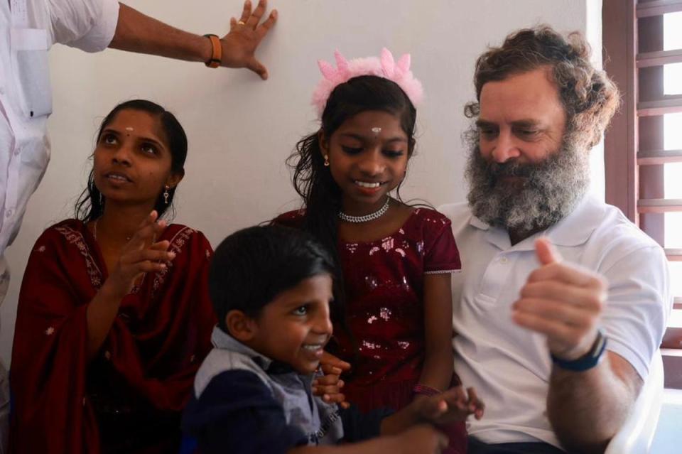 Rahul Gandhi with Jiji, a beneficiary of a housing project called Kaithangu, meaning helping hand, and her children at their new house in Wayanad in March (Supplied)