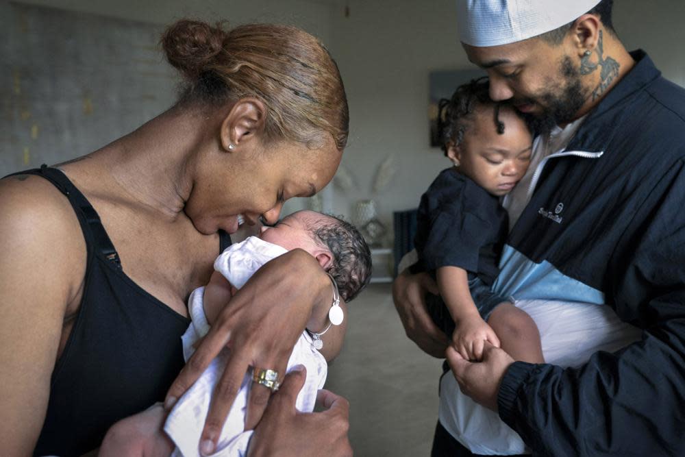 Aaliyah Wright, 25, of Washington, nuzzles her newborn daughter Kali, as her husband Kainan Wright, 24, of Washington, holds their son Khaza, 1, as he falls asleep, during a visit to the children’s grandmother in Accokeek, Md., Tuesday, Aug. 9, 2022. (AP Photo/Jacquelyn Martin)