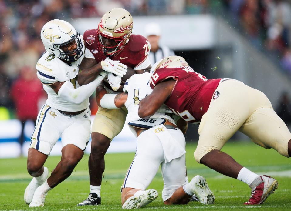 Florida State running back Roydell Williams is tackled by Georgia Tech defenders Trenilyas Tatum and Kyle Efford at Aviva Stadium.