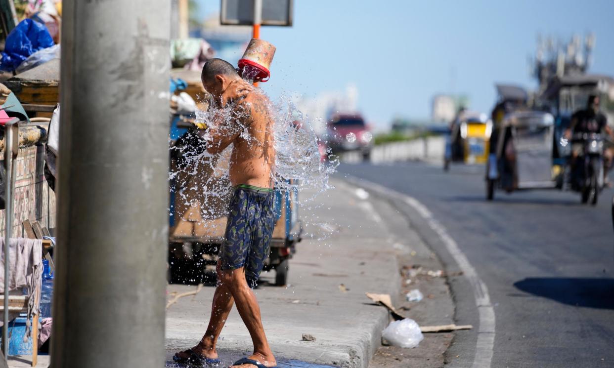 <span>A man tries to cool himself during hot temperatures in Manila, Philippines, last month.</span><span>Photograph: Aaron Favila/AP</span>