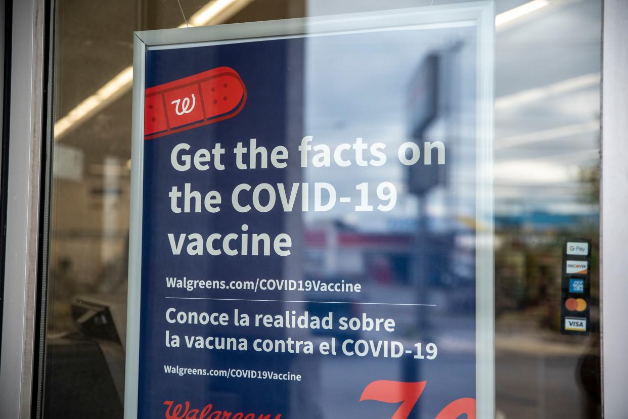 A sign about the COVID-19 vaccine is displayed on the window of a Walgreens in this file photo.