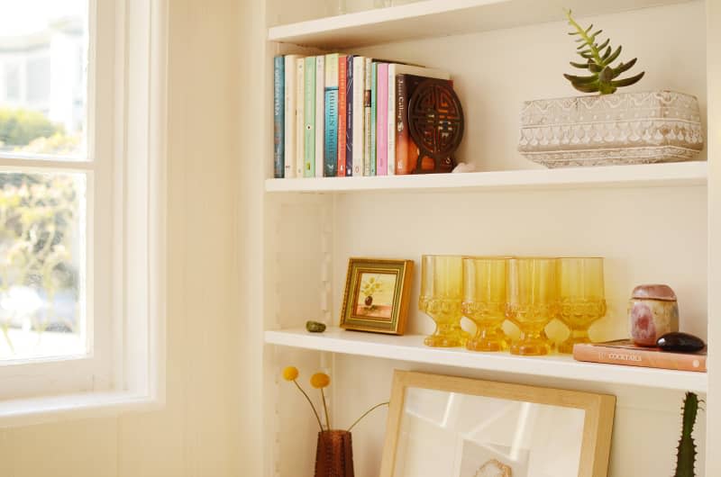 Vintage amber glassware on built in shelf in studio apartment.