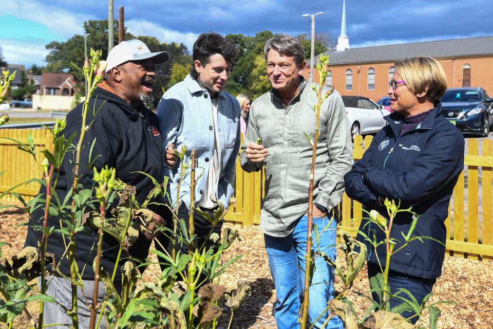 Chris Battle chats with Harrison, Randy, and Jenny Boyd as the family tastes the okra grown at the Payne Avenue Missionary Baptist Church Community Garden on Sunday, October 15, 2023 in Knoxville, Tenn.