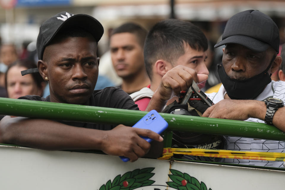 Inmates' relatives wait for news of their loved ones outside a jail where there was a deadly fire in Tulua, Colombia, Tuesday, June 28, 2022. Authorities say at least 49 people were killed after the fire broke out during what appeared to be an attempted riot early Tuesday. (AP Photo/Juan Jose Horta)