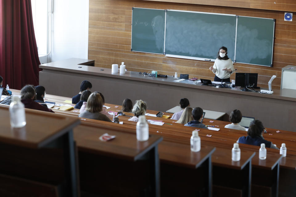 Students attend a lesson in an almost tempty amphitheatre at the university of Strasbourg, eastern France, Thursday, March 18, 2021. The world awaits a decision from Europe's top medical regulator into whether there is any evidence to show the AstraZeneca coronavirus vaccine is linked to a small number of blood clots reported in people across the continent. (AP Photo/Jean-Francois Badias)