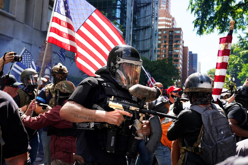 A member of the Proud Boys fires a paintball gun into a crowd of protesters against police brutality as the two sides clashed on Aug. 22 in Portland. For the second Saturday in a row, right-wing groups gathered in downtown Portland, sparking counterprotests and leading to violence. (Photo: Nathan Howard/Getty Images)