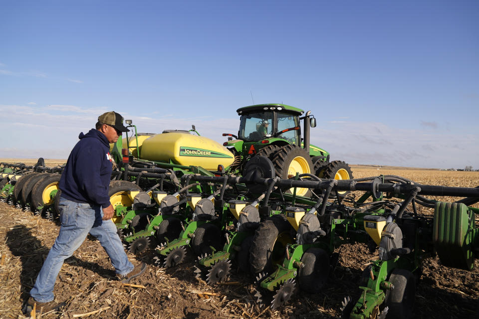 Don Schneider monitors as his son Bradon works a corn planter Friday, April 29, in Ovid, Colo. They pump water from a shallow aquifer for irrigation, and uses supply from the South Platte River to replenish the wells. (AP Photo/Brittany Peterson)