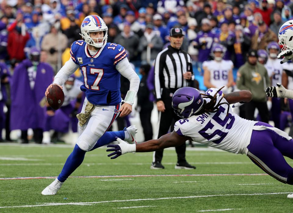 Bills quarterback Josh Allen rolls away from pressure by Vikings Za’Darius Smith. 