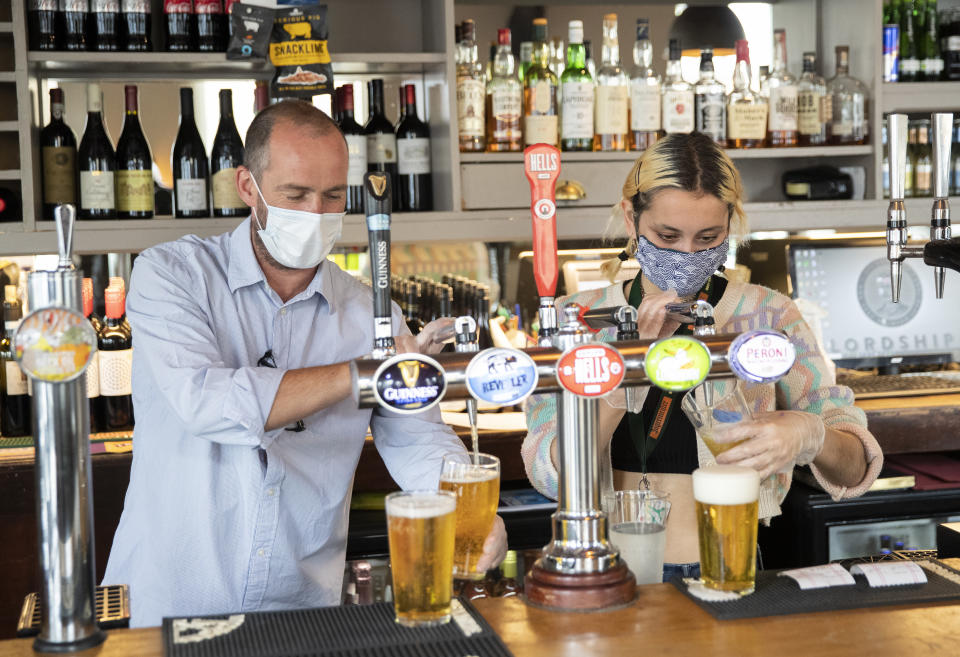 LONDON - JULY 04: Employees pull pints at the Lordship pub in East Dulwich on July 04, 2020 in London, England. The UK Government announced that Pubs, Hotels and Restaurants can open from Saturday, July 4th providing they follow guidelines on social distancing and sanitising. (Photo by John Phillips/Getty Images)